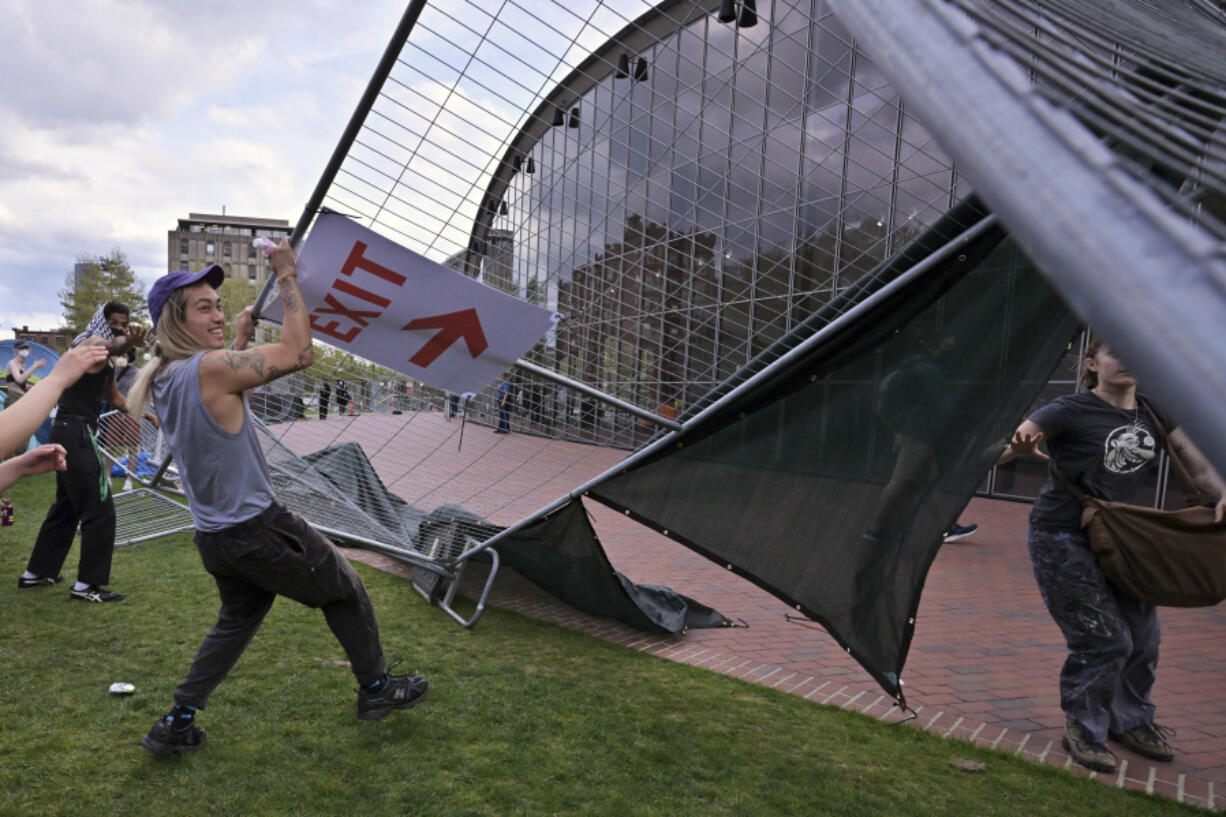 Demonstrators tear down barricades that had been erected outside a pro-Palestinian encampment at MIT, May 6, 2024, in Cambridge, Mass. Several hundred demonstrators crossed the barricades to join pro-Palestinian demonstrators that been given a deadline to leave the encampment.