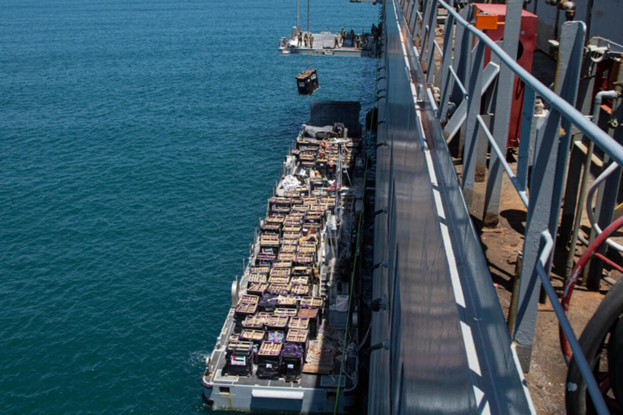 Humanitarian aid is lifted by a crane operated by soldiers assigned to the 7th Transportation Brigade (Expeditionary) from a Navy causeway at the Port of Ashdod, Israel, May 14, 2024. These soldiers are supporting the construction of the Joint Logistics Over-the-Shore system off the shore of Gaza.  (Staff Sgt. Malcolm Cohens-Ashley/U.S.