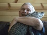 Joie Henney hugs his emotional support alligator named Wally, on Jan. 22, 2019, inside their home in York Haven, Pa. Henney credits Wally for helping relieve his depression for nearly a decade, says he&rsquo;s searching for the reptile after it went missing during a vacation to the coast of Georgia.