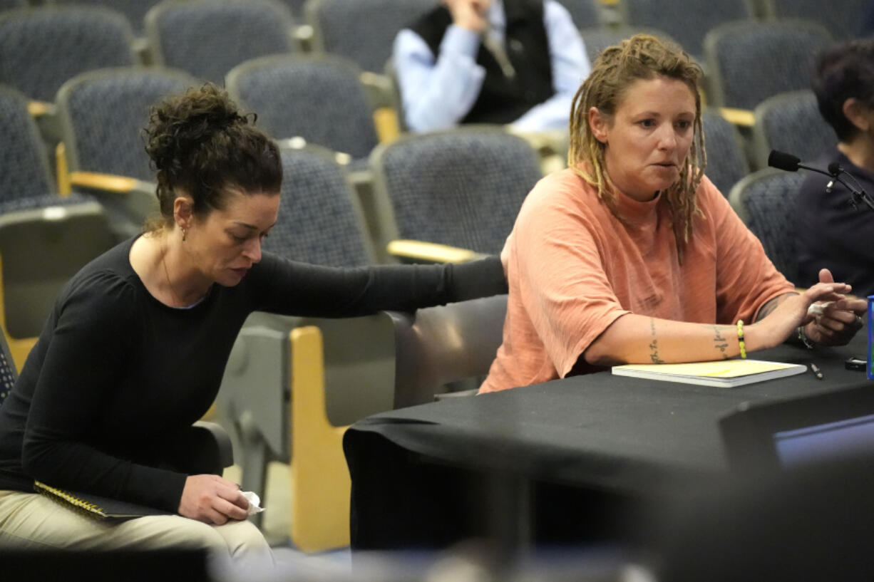Cara Lamb, ex-wife of shooter Robert Card, is comforted as she testifies, Thursday, May 16, 2024, in Augusta, Maine, during a hearing of the independent commission investigating the law enforcement response to the mass shooting in Lewiston, Maine. (AP Photo/Robert F.