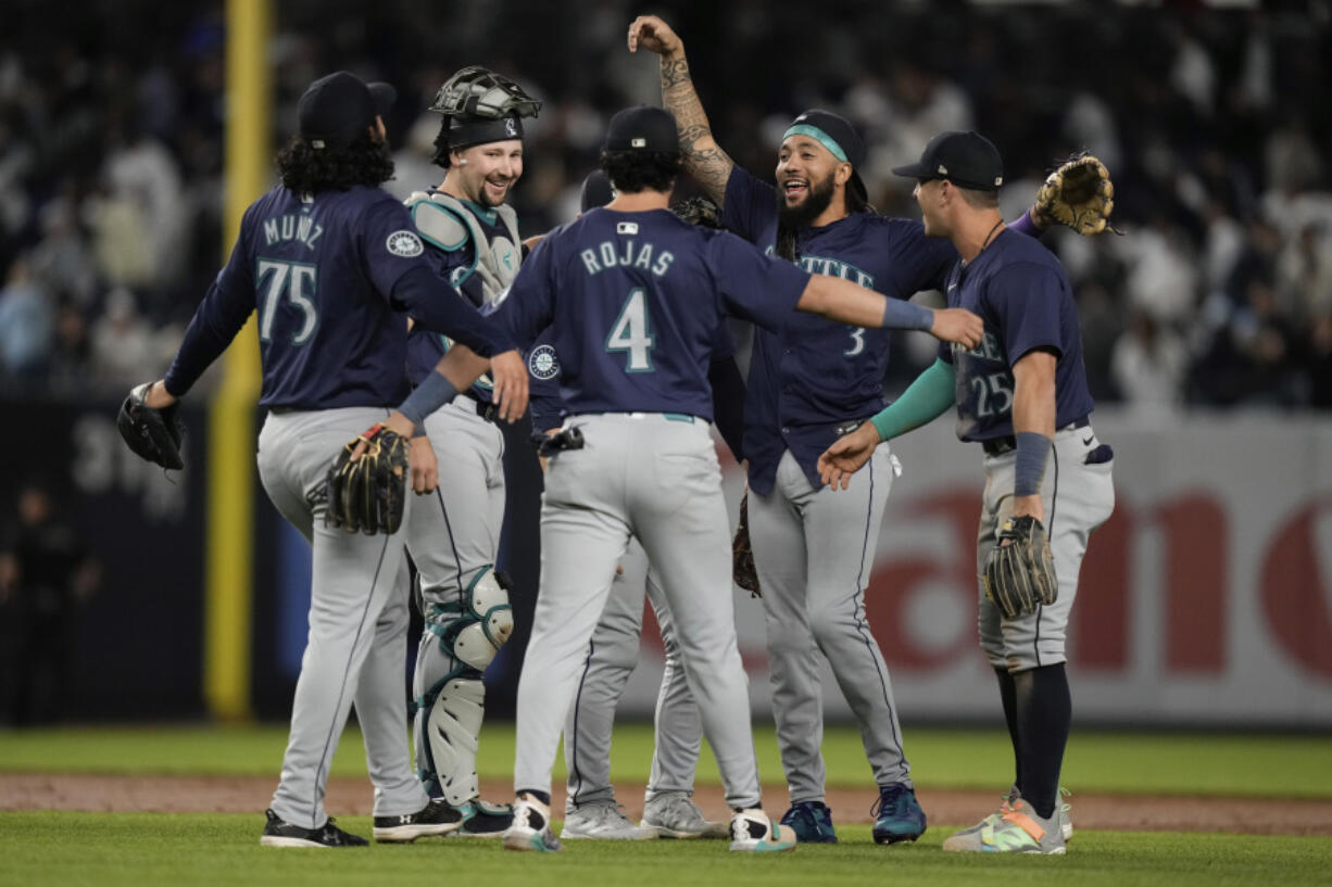 Seattle Mariners&#039; J.P. Crawford (3), and catcher Cal Raleigh celebrates with teammates after a baseball game against the New York Yankees, Monday, May 20, 2024, in New York. The Mariners won 5-4.