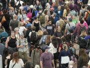 FILE - Travelers move through a security checkpoint in Denver International Airport ahead of the Memorial Day holiday on May 26, 2023, in Denver. A record number of Americans are expected to hit the pavement and the air over the 2024 Memorial Day weekend.