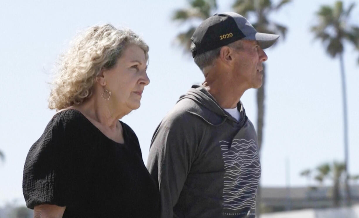 In this image taken from video, Australia&rsquo;s Debra Robinson stands with her husband Martin, following a media conference on the beach in San Diego, Tuesday, May 7, 2024 following the deaths in Mexico of their two sons during a surfing trip. The sons, Callum and Jake, and U.S. friend Jack Carter Rhoad, were allegedly killed by car thieves in Baja California, across the border from San Diego, somewhere around April 28 or 29.