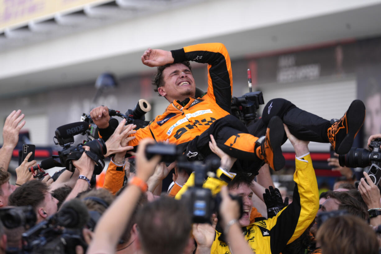 McLaren driver Lando Norris, of Britain, is lifted after winning the Miami Formula One Grand Prix auto race Sunday, May 5, 2024, in Miami Gardens, Fla.