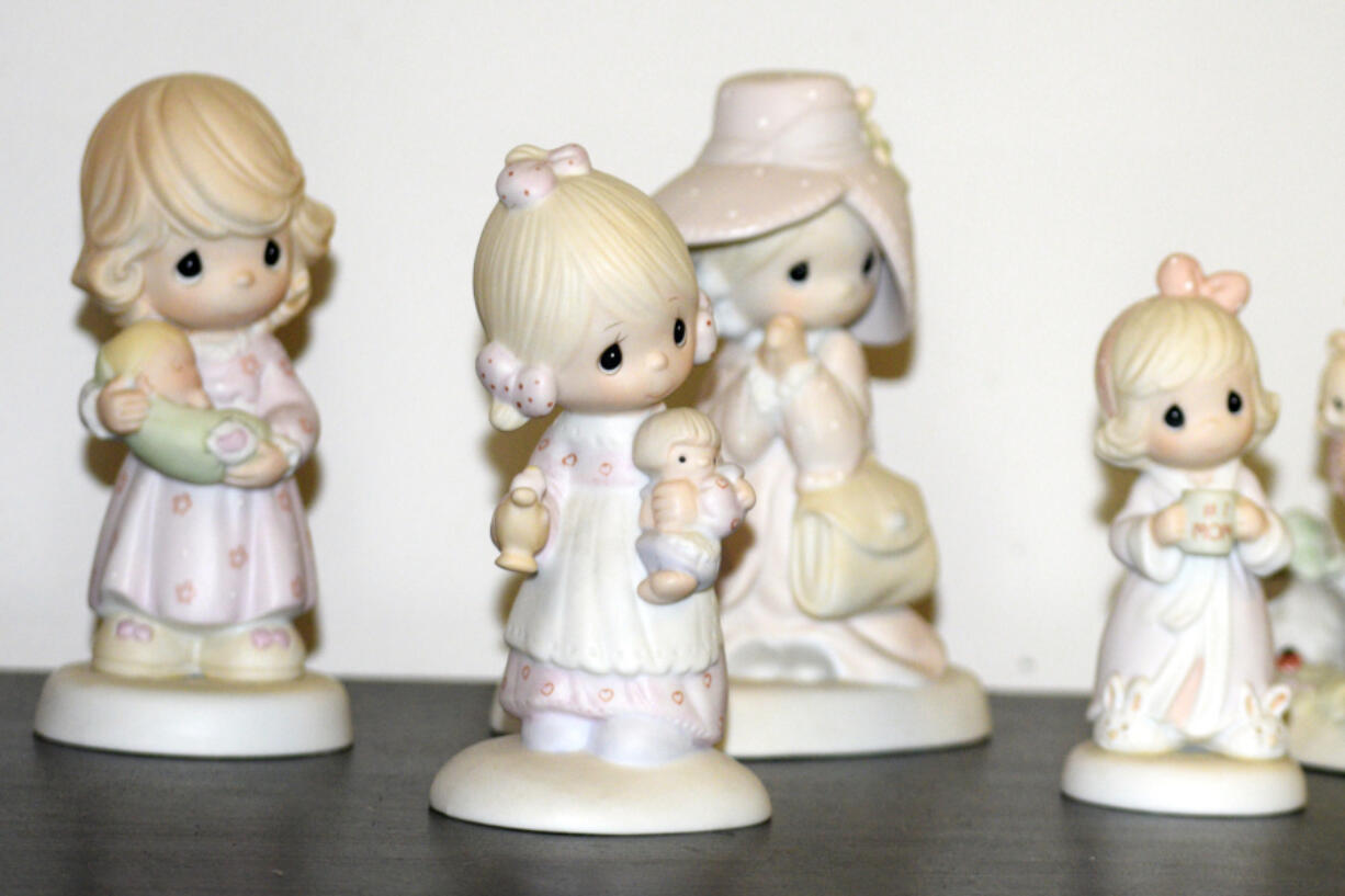A selection of Precious Moments figurines sit on a shelf, Thursday, May 23, 2024, in Blaine, Minn. Sam Butcher, the artist who created the Precious Moments figurines depicting angelic teardrop-eyed children, died early Monday, May 20, 2024, surrounded by family. He was 85.