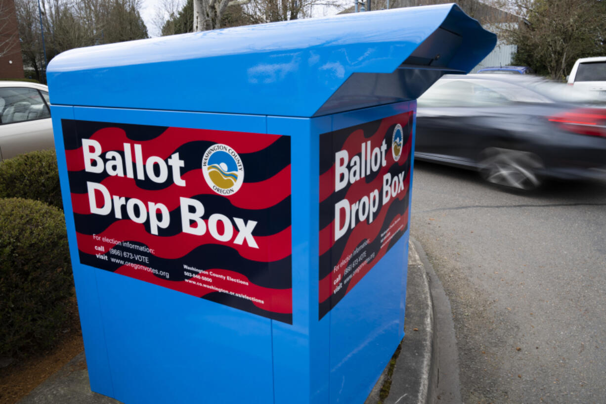 A car drives by a ballot drop box on Wednesday, March 6, 2024, in Sherwood, Ore. In Oregon&rsquo;s Multnomah County, home to Portland, the progressive district attorney who took office during the historical social justice movement of 2020 is being challenged by a more centrist candidate vowing to be tough on crime, highlighting the growing pressure on liberal prosecutors across the U.S. amid voter concerns over public drug use and disorder.
