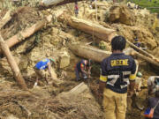 Villagers search Monday amongst the debris from a landslide in the village of Yambali in the Highlands of Papua New Guinea.