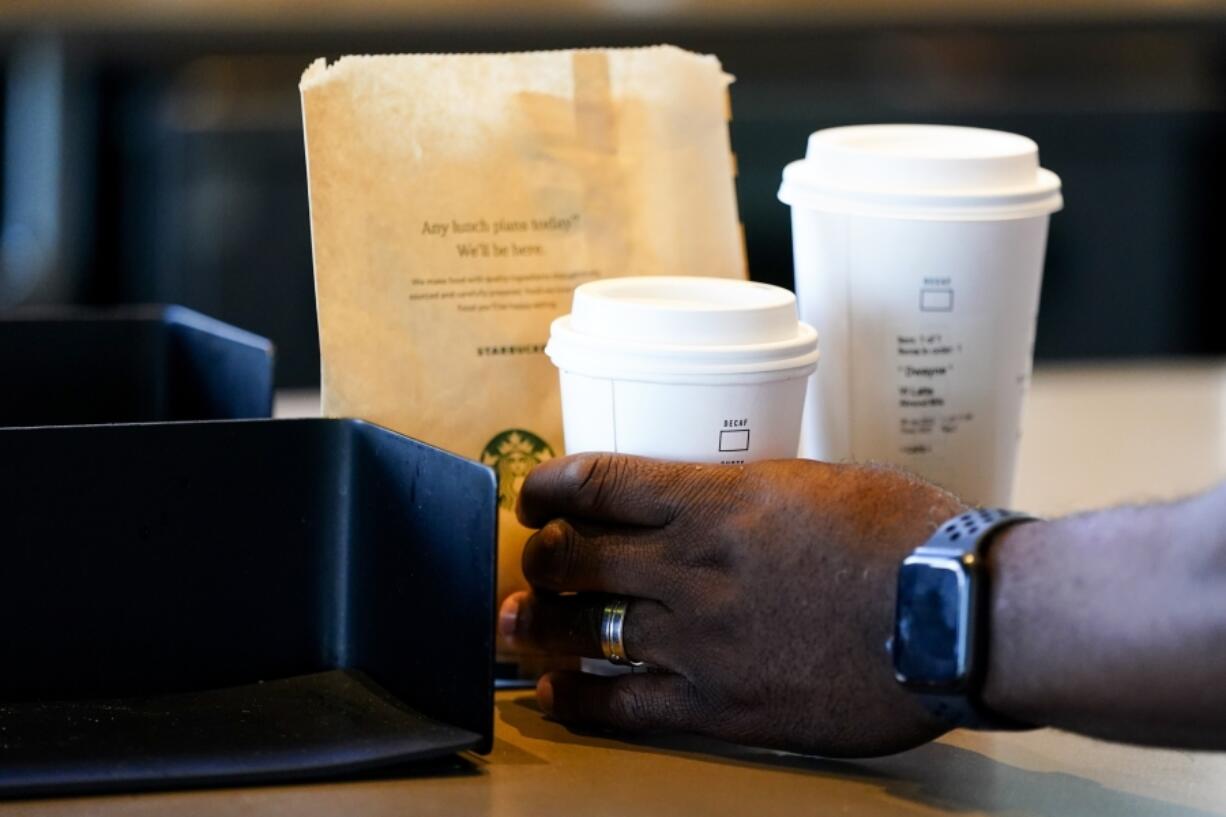 FILE - A customer picks up a drink at a Starbucks location on June 28, 2023, in Seattle. On Wednesday, May 15, 2024, the Commerce Department releases U.S. retail sales data for April.