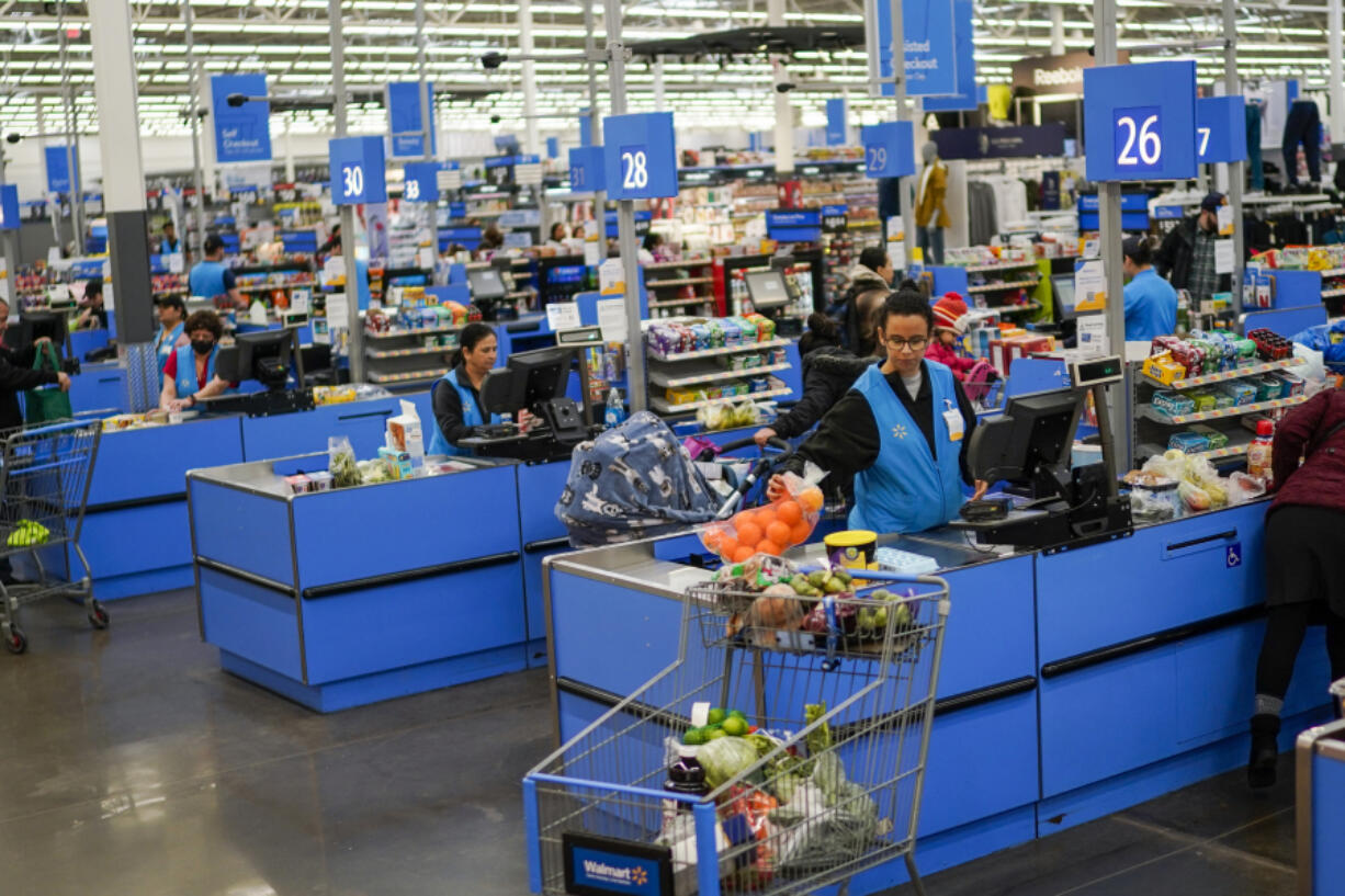 FILE - Cashiers process purchases at a Walmart Supercenter in North Bergen, N.J., on Feb. 9, 2023.