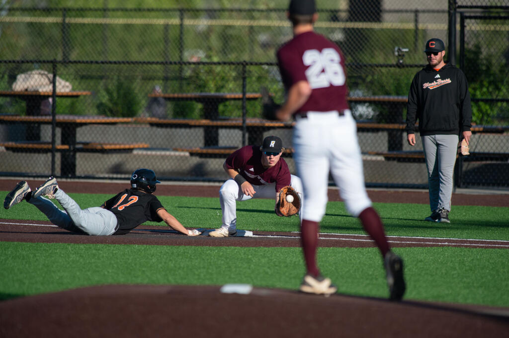 Ridgefield Raptors pitcher Travis Gibson throws over to first to keep Cowlitz Black Bears runner Jackson Babione close Thursday, May 30, 2024, at Ridgefield Outdoor Athletic Complex.