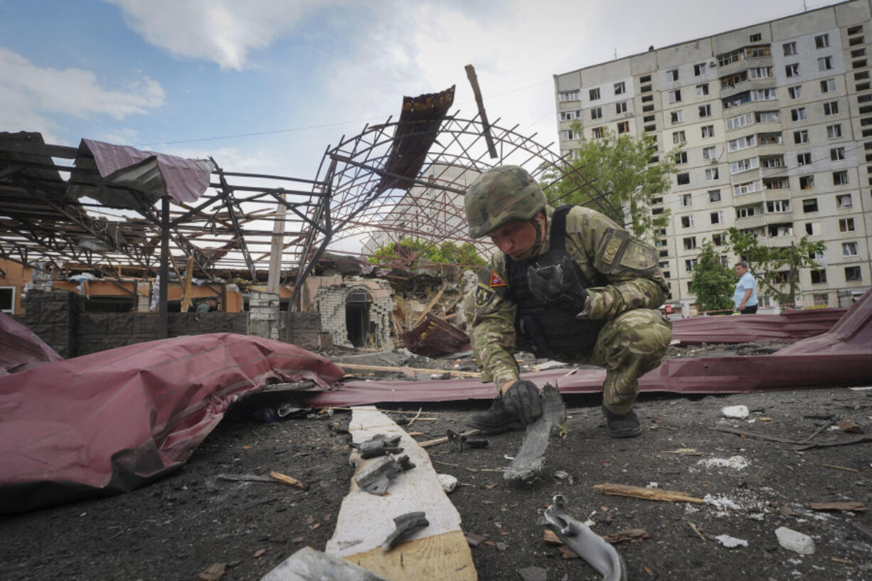 A sapper inspects fragments of a Russian air bomb that hit a living area injuring ten in Kharkiv, Ukraine, Wednesday, May 22, 2024.