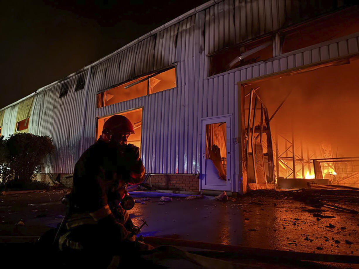 In this photo provided by the Ukrainian Emergency Service, emergency service personnel try to extinguish a fire following a Russian attack in Odesa, Ukraine, Wednesday, May 1, 2024.