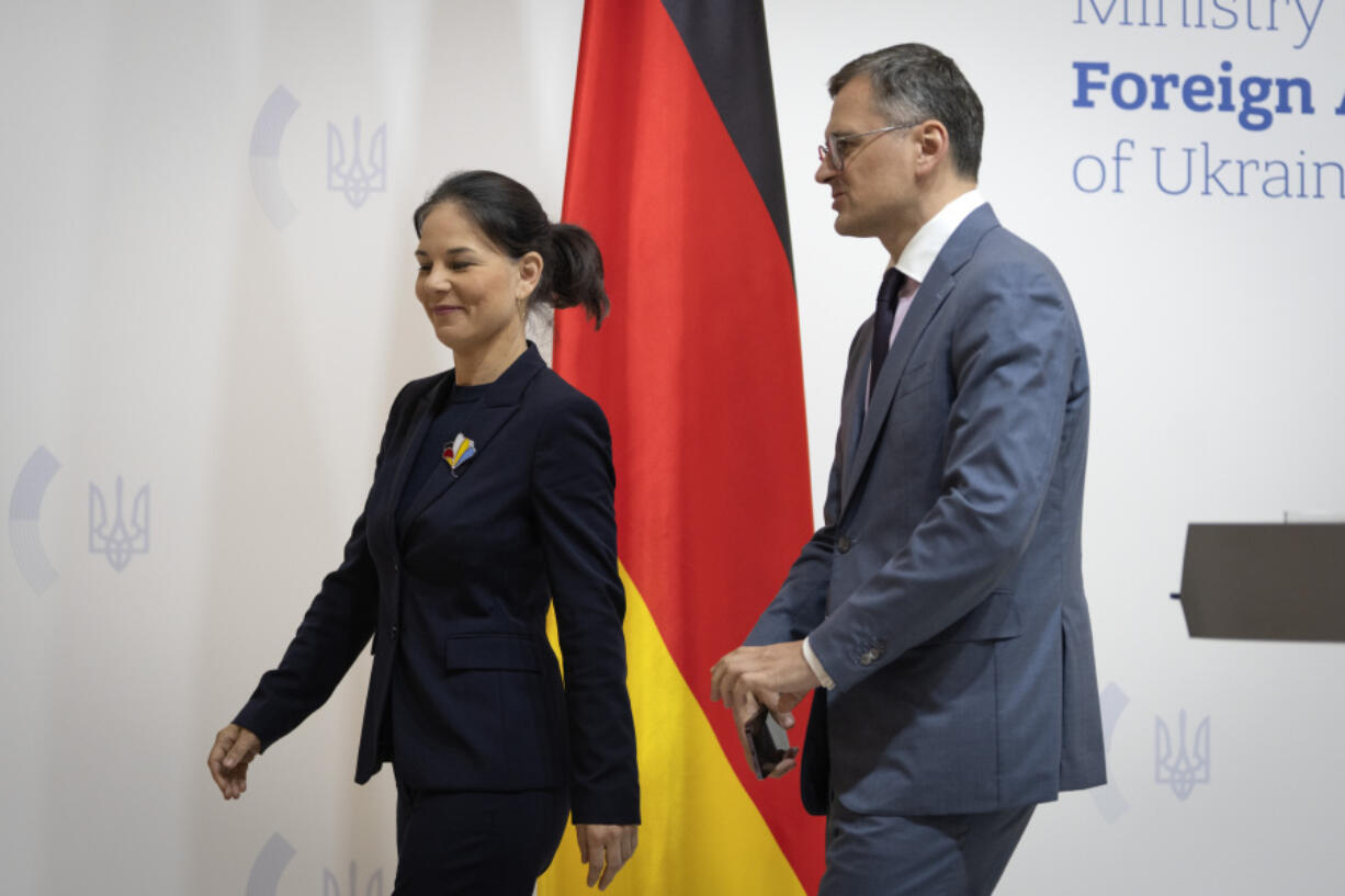 German Foreign Minister Annalena Baerbock, left, and Ukrainian Foreign Minister Dmytro Kuleba walk during their meeting in Kyiv, Ukraine, Tuesday, May 21, 2024.
