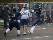 Kingsley Williams (right) celebrates her RBI single with teammate Kenzie Kuhnhausen (33) as coach Carrie Farrell looks on during Seton Catholic's 5-4 win over Riverside in the Class 1A state softball semifinals at Columbia Playfields in Richland on Friday, May 24, 2024.