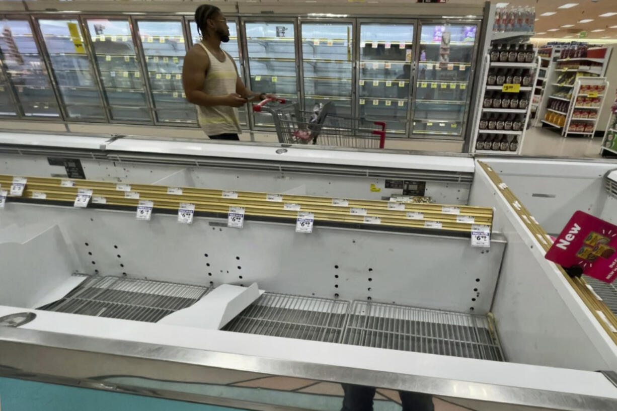 A shopper passes by empty rows in the frozen food section of a Winn-Dixie grocery near downtown Tallahassee, Fla., Sunday, May 12, 2024. The store was forced to remove perishable items after they lost power Friday morning from a powerful storm. Some of the strongest storms, including two EF-2 tornadoes confirmed by the National Weather Service in Tallahassee, rolled through early Friday, toppling trees across the region. According to the city&#039;s outage map, as of 9:11 pm. tonight, over 25,000 customers were still without power.