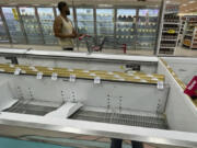 A shopper passes by empty rows in the frozen food section of a Winn-Dixie grocery near downtown Tallahassee, Fla., Sunday, May 12, 2024. The store was forced to remove perishable items after they lost power Friday morning from a powerful storm. Some of the strongest storms, including two EF-2 tornadoes confirmed by the National Weather Service in Tallahassee, rolled through early Friday, toppling trees across the region. According to the city&#039;s outage map, as of 9:11 pm. tonight, over 25,000 customers were still without power.