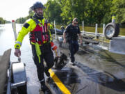 The Conroe firefighters with CFD&rsquo;s Rapid Intervention Team carry a pair of dogs rescued in a boat in the aftermath of a severe storm, Thursday, May 2, 2024, in Conroe, Texas.