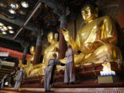 Buddhists monks clean Buddha statues May 7 ahead of the upcoming birthday of Buddha at the Jogye temple in Seoul, South Korea.