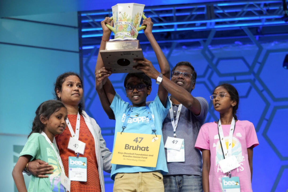 Bruhat Soma, 12, of Tampa, Fla., holds the trophy with members of his family after winning the Scripps National Spelling Bee, in Oxon Hill, Md., Thursday, May 30, 2024.