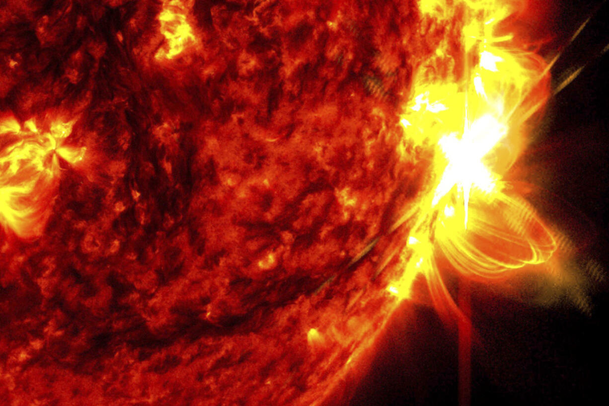 This image provided by NASA&rsquo;s Solar Dynamics Observatory shows a solar flare, right, on May 14, 2024, captured in the extreme ultraviolet light portion of the spectrum colorized in red and yellow. An international team of mathematicians and scientists reported Wednesday, May 22, 2024, that the sun&rsquo;s magnetic field originates much closer to the surface than previously thought.