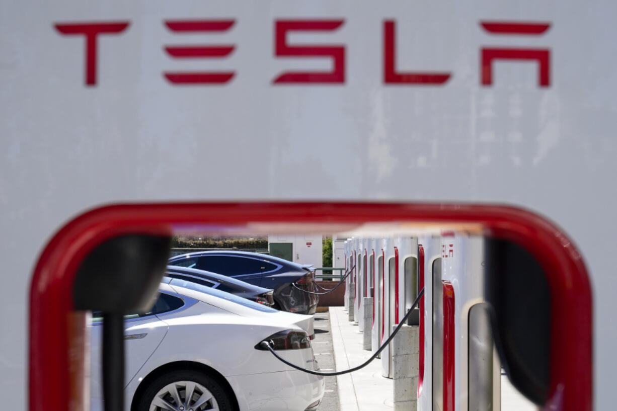 FILE - Tesla vehicles charge at a station in Emeryville, Calif., Aug. 10, 2022. Federal highway safety investigators want Tesla to tell them how and why it developed the fix in a recall of more than 2 million vehicles equipped with the company&rsquo;s Autopilot partially automated driving system. In a letter to Tesla posted on the agency&rsquo;s website Tuesday, May 7, 2024, investigators wrote that they could not find a difference between warnings to the driver to pay attention before the recall and after the new software was sent out.  (AP Photo/Godofredo A.