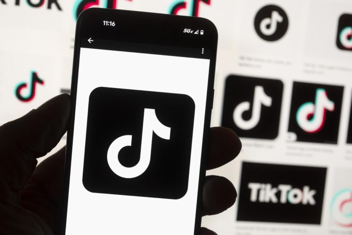 FILE - The TikTok logo is displayed on a mobile phone in front of a computer screen, Oct. 14, 2022, in Boston. TikTok will begin labeling content created using artificial intelligence when it&rsquo;s uploaded from certain platforms. TikTok says its efforts are an attempt to combat misinformation from being spread on its social media platform. The announcement came on ABC&rsquo;s &ldquo;Good Morning America&rdquo; on Thursday, May 9, 2024.