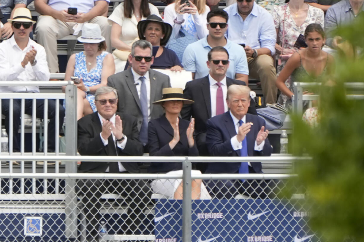 Republican presidential candidate former President Donald Trump, seated right with Melania Trump and her father, Viktor Knavs, attends a graduation ceremony for his son Barron at Oxbridge Academy Friday, May 17, 2024, in West Palm Beach, Fla.