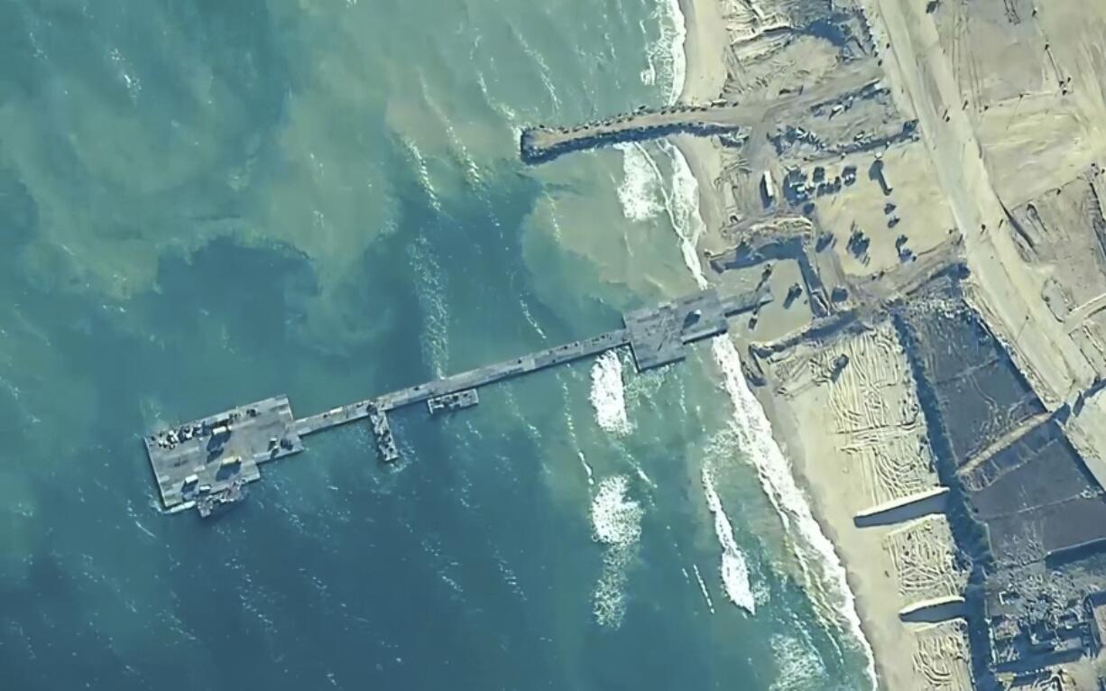 FILE - The image provided by U.S, Central Command, shows U.S. Army soldiers assigned to the 7th Transportation Brigade (Expeditionary), U.S. Navy sailors assigned to Amphibious Construction Battalion 1, and Israel Defense Forces placing the Trident Pier on the coast of Gaza Strip on May 16, 2024.  A U.S. built temporary pier that had been used to deliver additional humanitarian aid into Gaza was damaged by rough seas and has temporarily suspended operations. That&rsquo;s according to three U.S. officials who spoke to The Associated Press on Tuesday. (U.S.