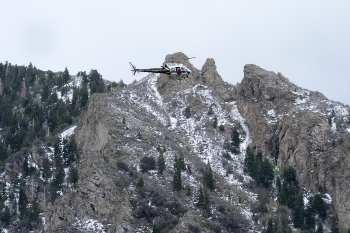 A Utah Department of Public Safety helicopter carries rescuers from Hidden Valley Park on Thursday, May 9, 2024, Thursday, May 9, 2024, in Sandy, Utah. One skier was rescued and two remained missing following an avalanche in the mountains outside of Salt Lake City. The slide happened after several days of spring snowstorms.