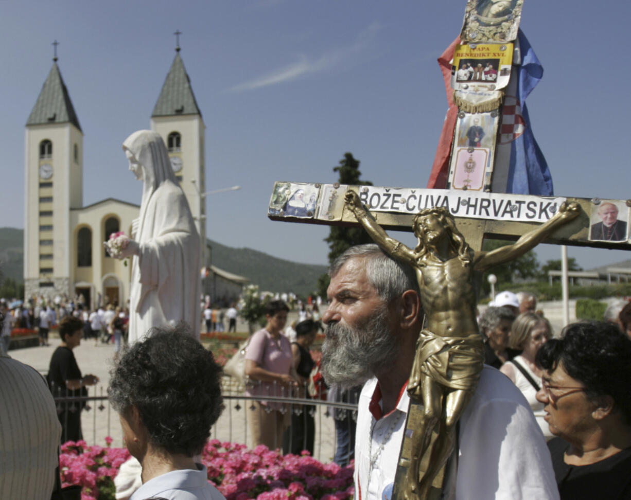 Pilgrims walk around a statue of the Blessed Virgin Mary near the church of St. James in Medjugorje, Bosnia and Herzegovina, some 120 kilometers (75 miles) south of the Bosnian capital of Sarajevo on Sunday, June 25, 2006. On Friday, May 17, 2024, the Vatican will issue revised norms for discerning apparitions &ldquo;and other supernatural phenomena,&rdquo; updating a set of guidelines first issued in 1978.