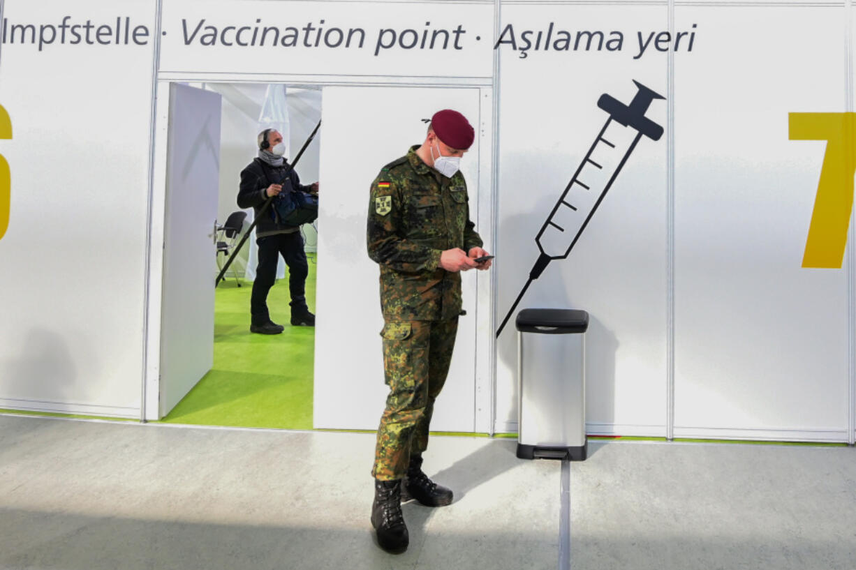 FILE - A soldier of the German Armed Forces Bundeswehr stands inside a new vaccination centre at the former Tempelhof airport in Berlin, Germany, before its opening on Monday, March 8, 2021. Germany has scrapped a requirement for its military servicepeople to be vaccinated against COVID-19. Members of the German military, the Bundeswehr, are required to get vaccinations against a number of diseases &mdash; including measles, mumps and flu. COVID-19 was added to the list in November 2021, meaning that anyone who refused to get vaccinated against it could face disciplinary measures.