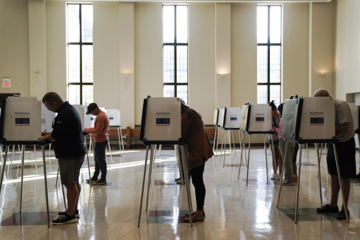 FILE - People vote on Election Day, Nov. 7, 2023, at Knox Presbyterian Church in Cincinnati. Voting rights advocates asked a federal judge on Friday, May 24, 2024, to strike down restrictions contained in Ohio&rsquo;s sweeping 2023 election law that they say restrict a host of trusted individuals from helping voters with disabilities cast absentee ballots. (AP Photo/Joshua A.