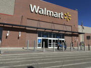 FILE - Shoppers exit a Walmart store, Feb. 21, 2024, in Englewood, Colo. Walmart on Tuesday, May 14, 2024, announced layoffs affecting several hundred jobs at the retail giant&rsquo;s campus offices.