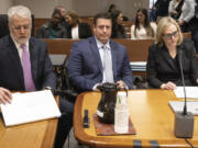 Auburn Police Officer Jeffrey Nelson, center, is flanked by two of his defense attorneys as Nelson&rsquo;s tmurder rial gets underway, Thursday, May 16, 2024 in Kent, Wash. On the left is Tim Leary, to the right is Emma Scanlan. Nelson is charged with murder in the death of a 26-year-old man outside a convenience store.