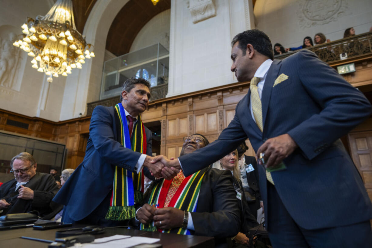 South Africa&rsquo;s agents Vusimuzi Madonsela, seated, and Cornelius Scholtz, left, are greeted as they wait for the start of hearings at the International Court of Justice, in The Hague, Netherlands, Thursday, May 16, 2024. The U.N.&rsquo;s top court opened two days of hearings in a case brought by South Africa to see whether Israel needs to take additional measures to alleviate the suffering in war-ravaged Gaza.