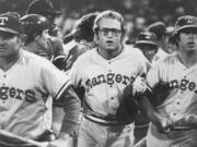 FILE - In this image provided by Special Collections, Cleveland State University, Texas Rangers&#039; Jeff Burroughs, center, runs off the field with his teammates during the Beer Night melee at Cleveland Stadium, June 4, 1974, in Cleveland. The Cleveland Indians forfeited the baseball game to the Rangers after fans, fueled by 10-cent beers, stormed the field in the ninth inning.