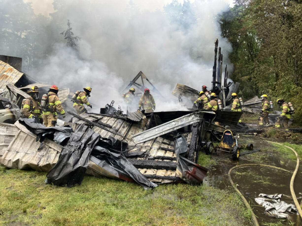 Firefighters battle a blaze that destroyed a large shop building Monday morning on a property north of Ridgefield. A woman was found dead inside the shop. The Clark County Medical Examiner&rsquo;s Office on Thursday identified her as 44-year-old Melissa Adams of Ridgefield.