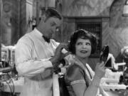 Clara Bow gets a haircut on set during a break from filming &ldquo;Red Hair&rdquo; for Paramount, circa 1928.