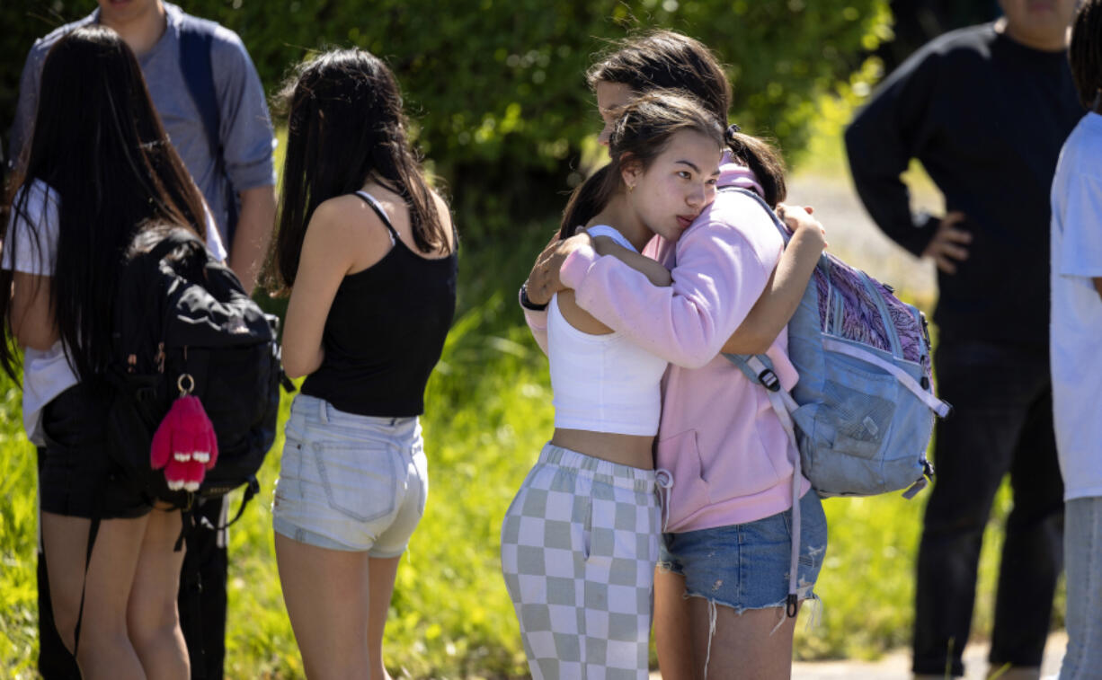 Students console each other after a shooting outside of Garfield High School on Thursday, June 6, 2024, in Seattle.