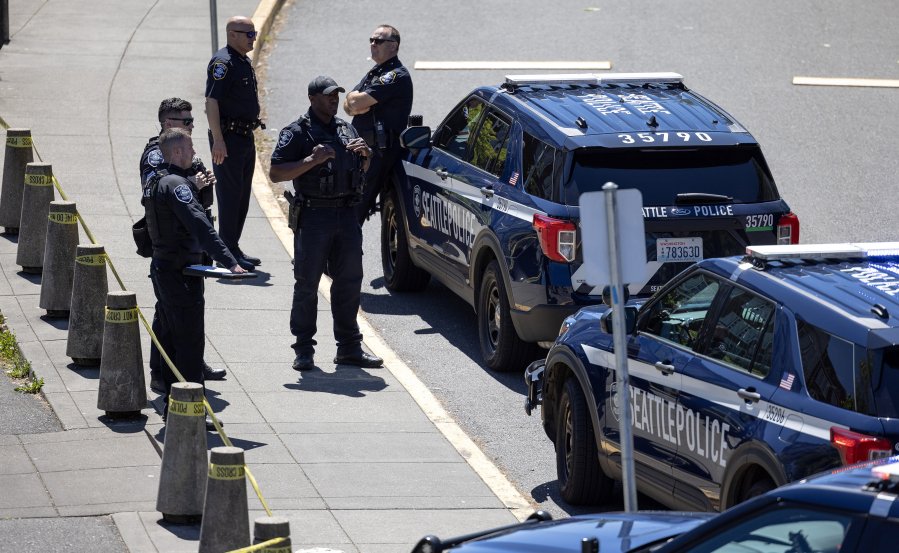 Police stand outside of Garfield High School on Thursday, June 6, 2024, in Seattle.