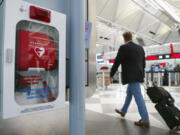 A traveler passes an Automated External Defibrillator in Terminal 1 Nov. 12, 2003, at O&rsquo;Hare International Airport in Chicago. An Automated External Defibrillator (AED) is a user-friendly device that when used properly on a person suffering a sudden cardiac arrest administers an electric shock to the heart. Its built-in microprocessor then assesses the patient&rsquo;s heart rhythm, judging whether more defibrillation would be needed. The Chicago Airport System implemented the first public-access defibrillation program at all its airports, including O&rsquo;Hare International Airport. Defibrillators are strategically located throughout the airport terminals within a one-minute walk from any point in the airport. The units are in cabinets that are directly linked to the City of Chicago&rsquo;s emergency medical services.