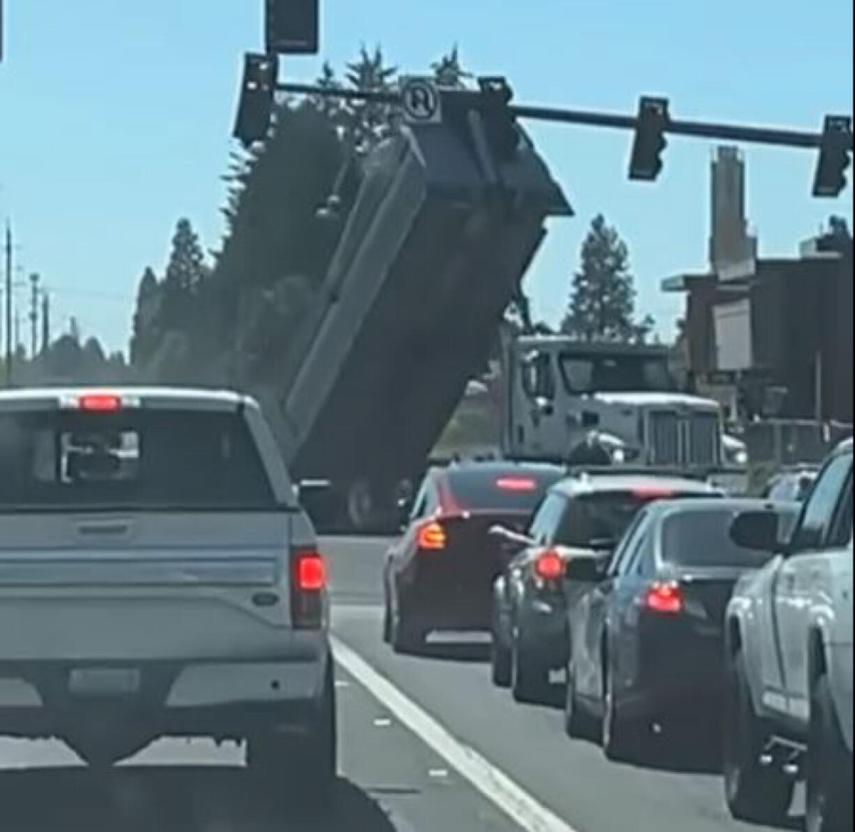 A video shared on social media shows a dump truck as it crashes its raised bed into a signal mast arm on First Street in east Vancouver.