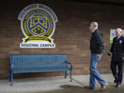 Gov. Jay Inslee, left, and Commissioner Dave Miller of the Criminal Justice Training Commission walk past the logo for Clark County&rsquo;s law enforcement academy in east Vancouver on opening day in January.