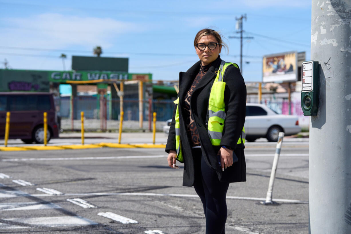 Cindi Enamorado stands beside a memorial for her brother, Raymond Olivares, outside his Los Angeles home. Olivares died after being hit by a speeding car while crossing the street to the home he had just bought.