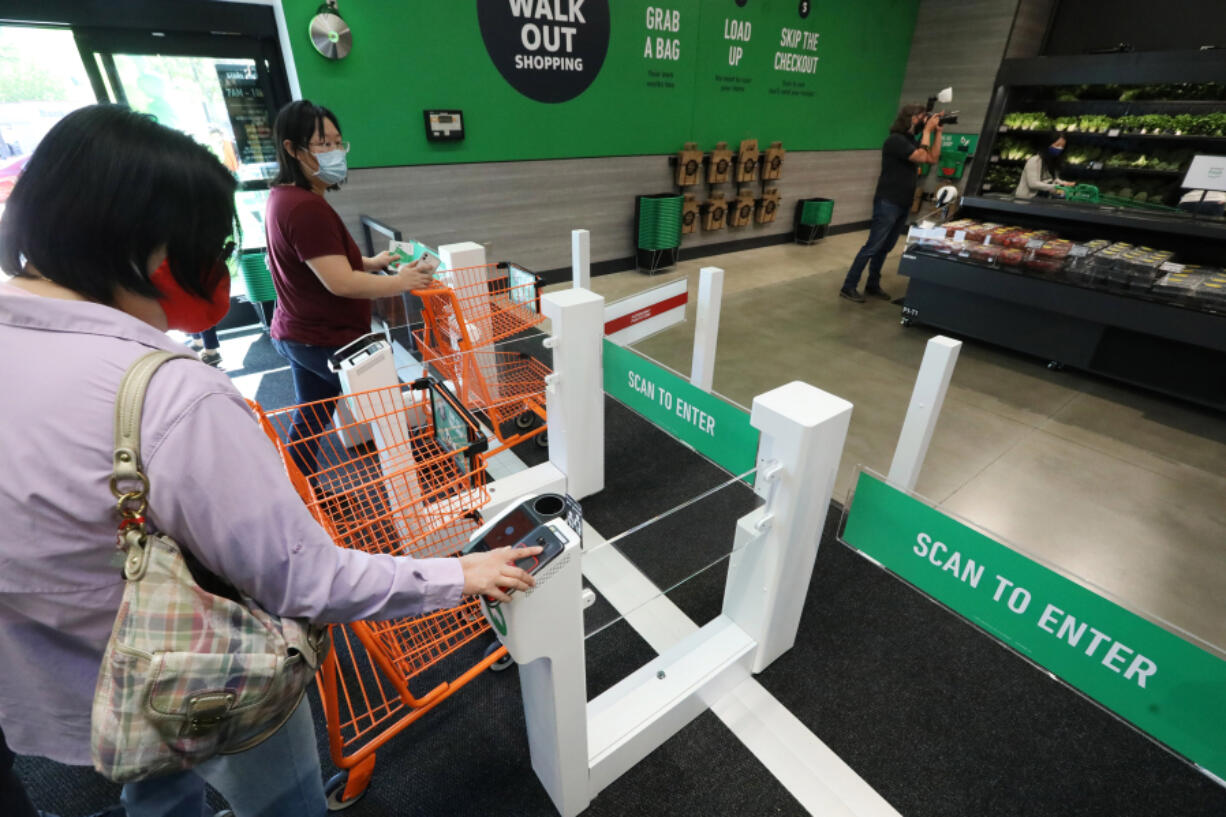 Customers check in with an app or credit card at the first Amazon Fresh in Washington, and the only one with both cashierless technology mixed with cashiers, on opening day, Thursday, June 17, 2021 in Bellevue, Washington. These shoppers won&rsquo;t have to go to a cashier.