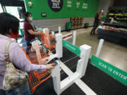 Customers check in with an app or credit card at the first Amazon Fresh in Washington, and the only one with both cashierless technology mixed with cashiers, on opening day, Thursday, June 17, 2021 in Bellevue, Washington. These shoppers won&rsquo;t have to go to a cashier.