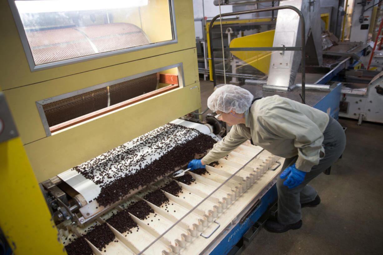 Zofia Zhabura gathers cocoa drops to count during processing in 2014 at the Blommer Chocolate Co. factory in Chicago. The company plans to shut down the Chicago factory after 85 years.