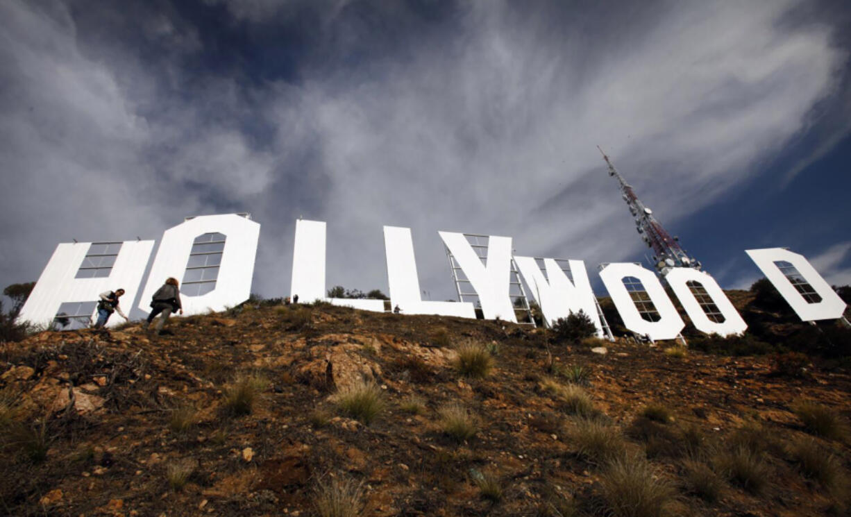 Journalists walk around the Hollywood sign following a ceremony to mark the end of the over nine-week refurbishment of the landmark on Dec. 4, 2012, in Hollywood.