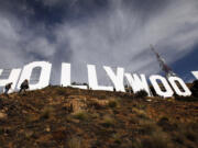 Journalists walk around the Hollywood sign following a ceremony to mark the end of the over nine-week refurbishment of the landmark on Dec. 4, 2012, in Hollywood.