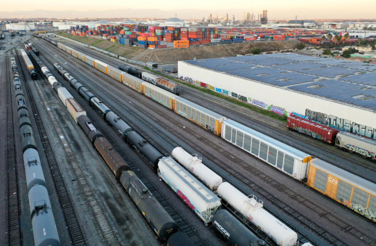 In an aerial view, freight rail cars sit in a rail yard near shipping containers on Nov. 22, 2022, in Wilmington, California.